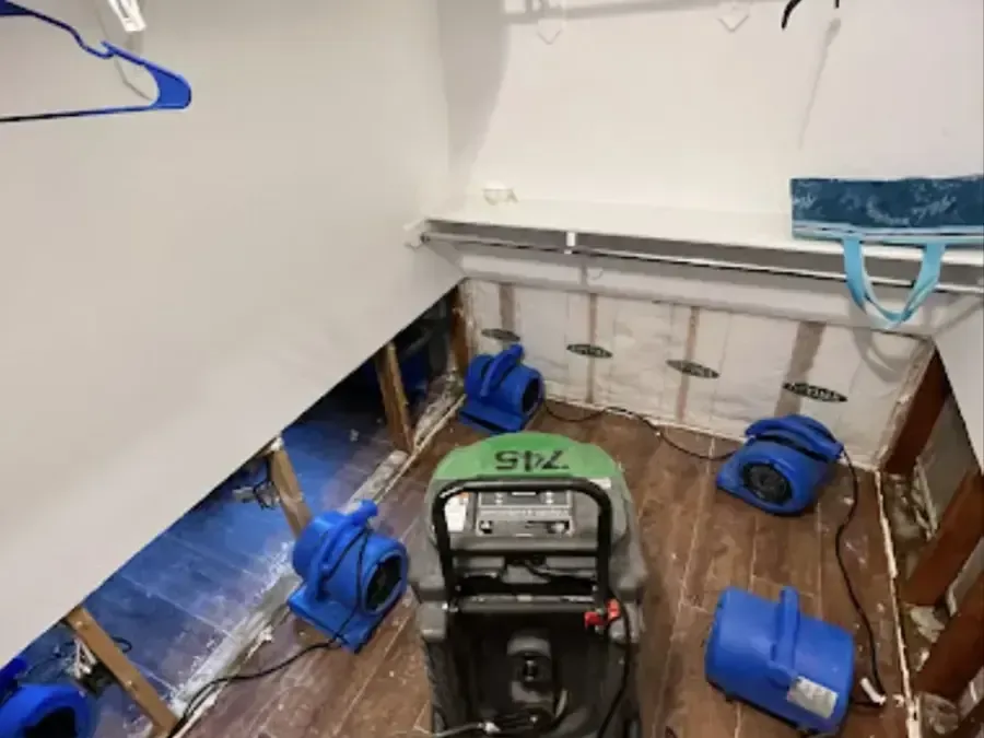 Flood-cut walls with air movers and a dehumidifier running in an emptied room