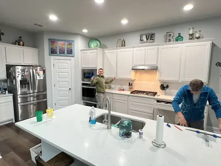 Crew restoring a kitchen after a leak from a supply pipe under the sink