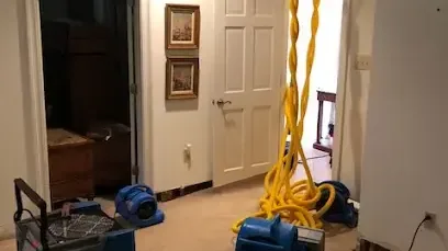 Air movers and a dehumidifier set up to dry a home after a water leak