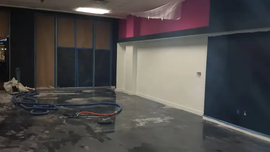 A flooded room with hoses and drying equipment set out for water removal after a storm