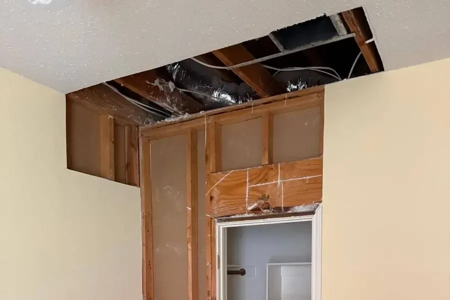 Ceiling drywall opened to dry the framing after a leak from above